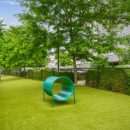 Gated dog park with dog tunnel and view of residences